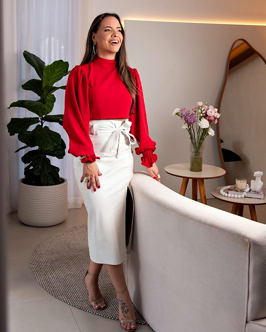 Alinie Araujo de blusa vermelha em ambiente de decoração contemporânea