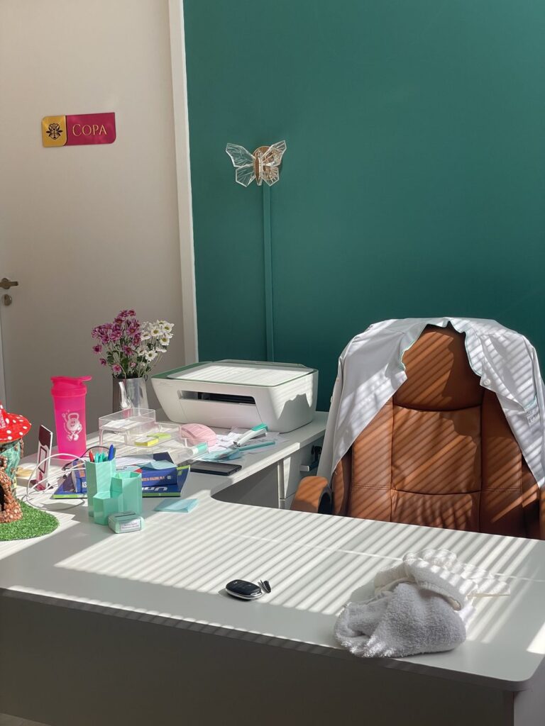 Sala de atendimento da Kolmeeia com maca preparada e produtos sobre a bancada