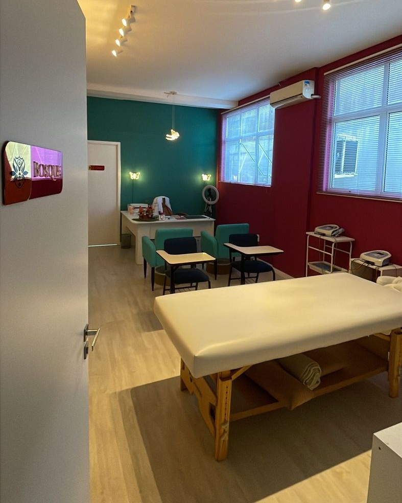 Sala ampla da Kolmeeia com macas de atendimento e paredes coloridas